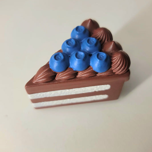 Blueberry chocolate cake magnet close-up showing detailed layers, frosting and blueberry topping