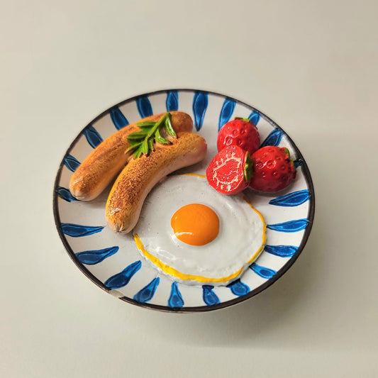 Egg and sausage magnet close-up showing detailed fried eggs and sausage presentation