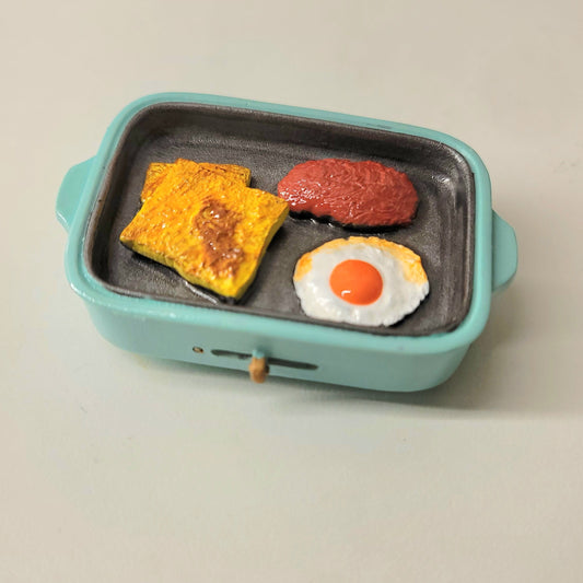 Steak and egg blue skillet magnet close-up showing detailed meat, fried egg and pan design