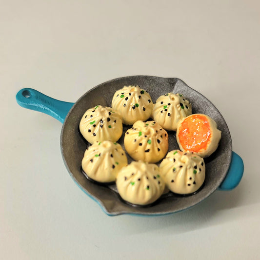 Baozi skillet magnet close-up showing detailed buns in pan and traditional cooking presentation