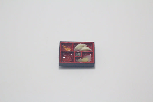 Bento box magnet close-up showing detailed rice, vegetables and traditional meal presentation