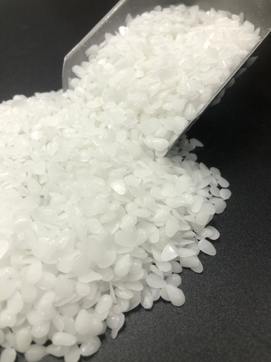 White beeswax pellets close-up showing texture and quality, premium candle-making ingredient